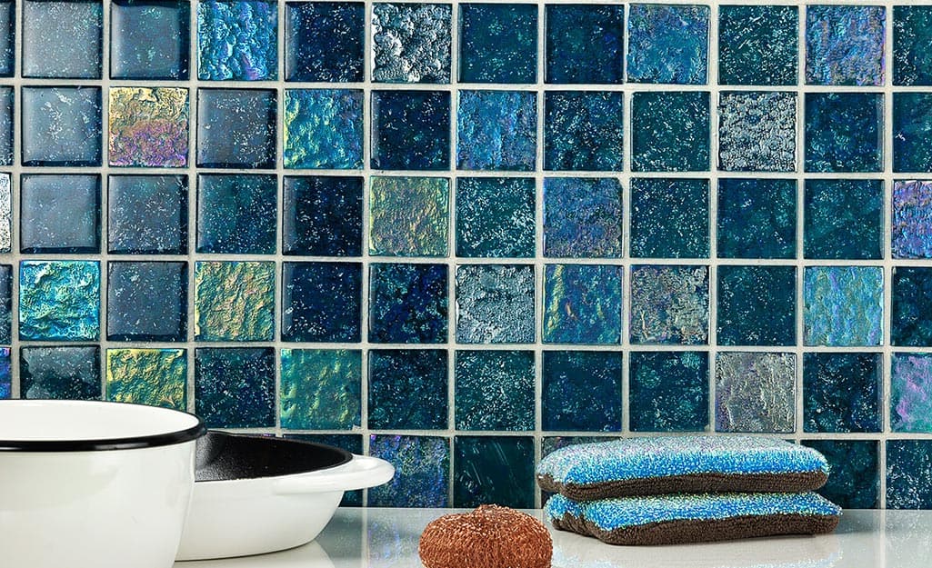 Kitchen backsplash made with blue, iridescent tiles and white grout. Kitchen backsplash made with blue, iridescent tiles and white grout.
