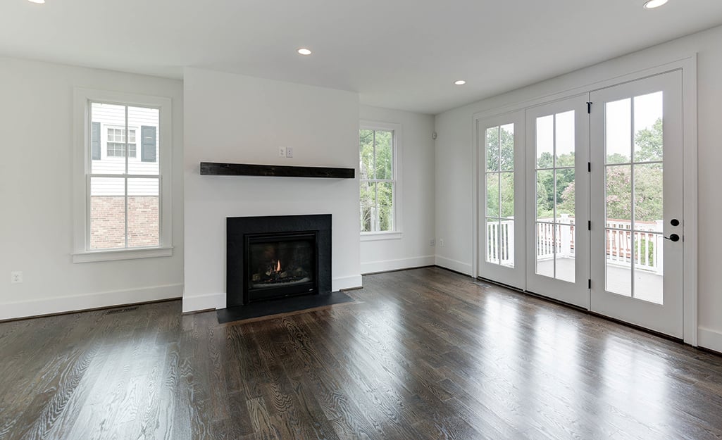 An empty living room with dark wood floor. An empty living room with dark wood floor.