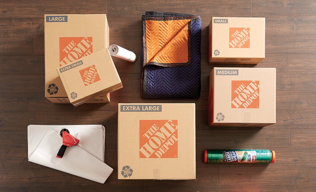 Home Depot boxes, moving blankets and packing paper lying on a wood floor. Home Depot boxes, moving blankets and packing paper lying on a wood floor.