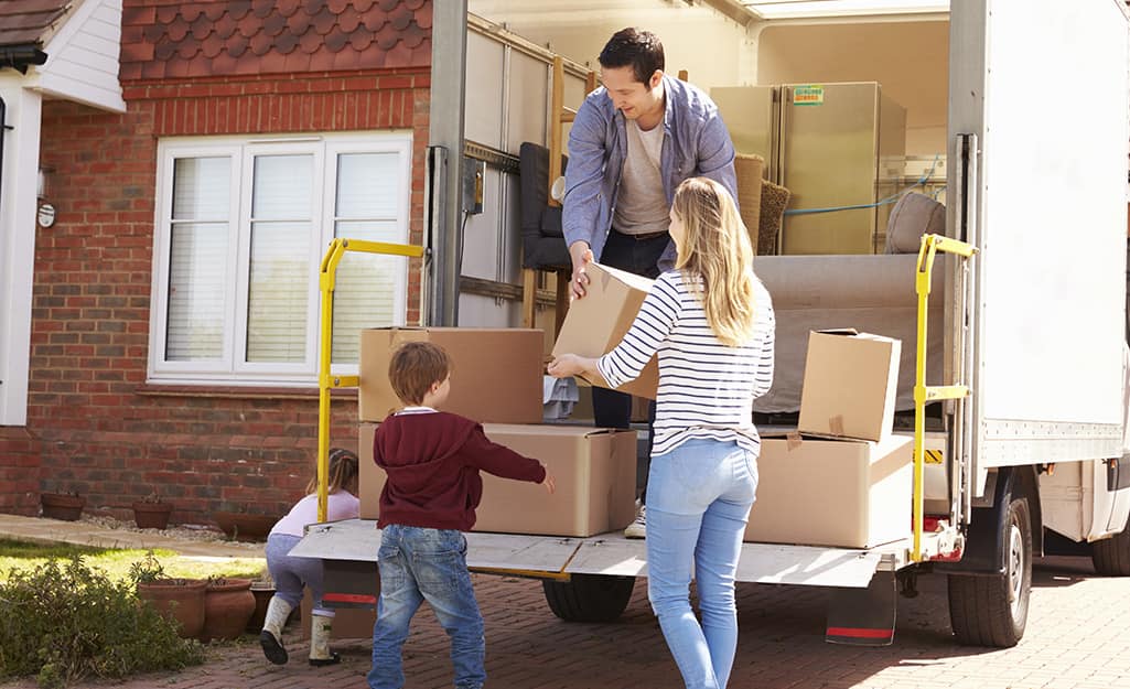 Couple loading small boxes into a moving truck. Couple loading small boxes into a moving truck.