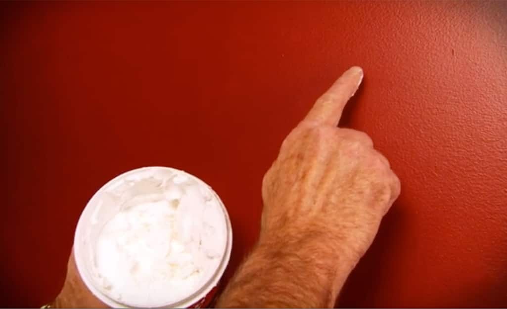 A person applying joint compound to a wall. A person applying joint compound to a wall.