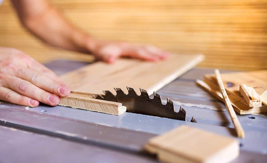 A person cuts plywood for a kitchen cabinet refacing. A person cuts plywood for a kitchen cabinet refacing.
