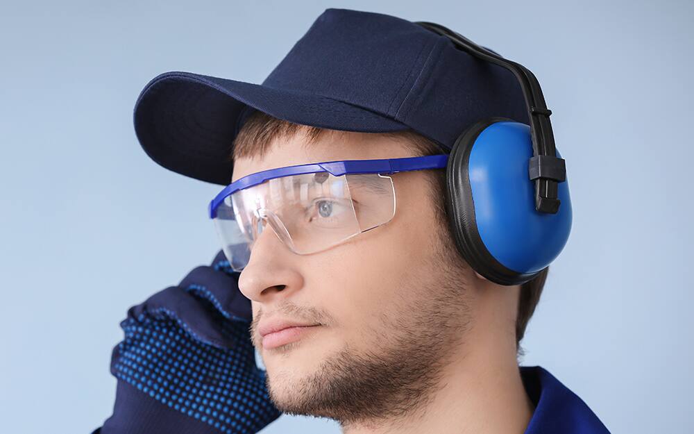 man wearing a hat and gloves and safety glasses and ear protection