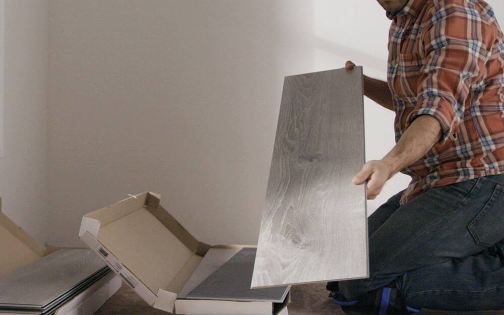 person removing laminate flooring
