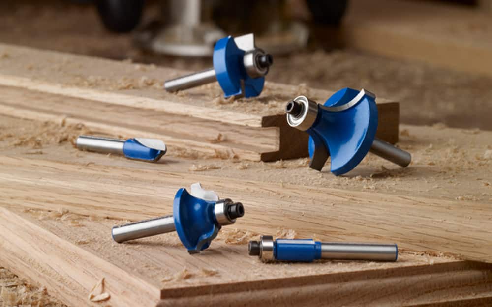 A set of router bits on a wood surface. A set of router bits on a wood surface.