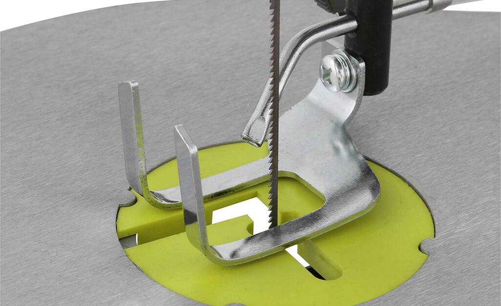 A thin scroll saw blade installed through the saw table. A thin scroll saw blade installed through the saw table.