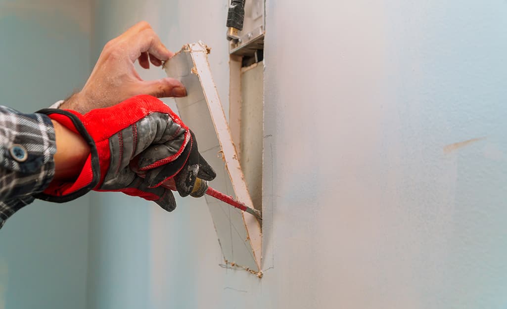A person's hand pulling apart the cut wall. A person's hand pulling apart the cut wall.