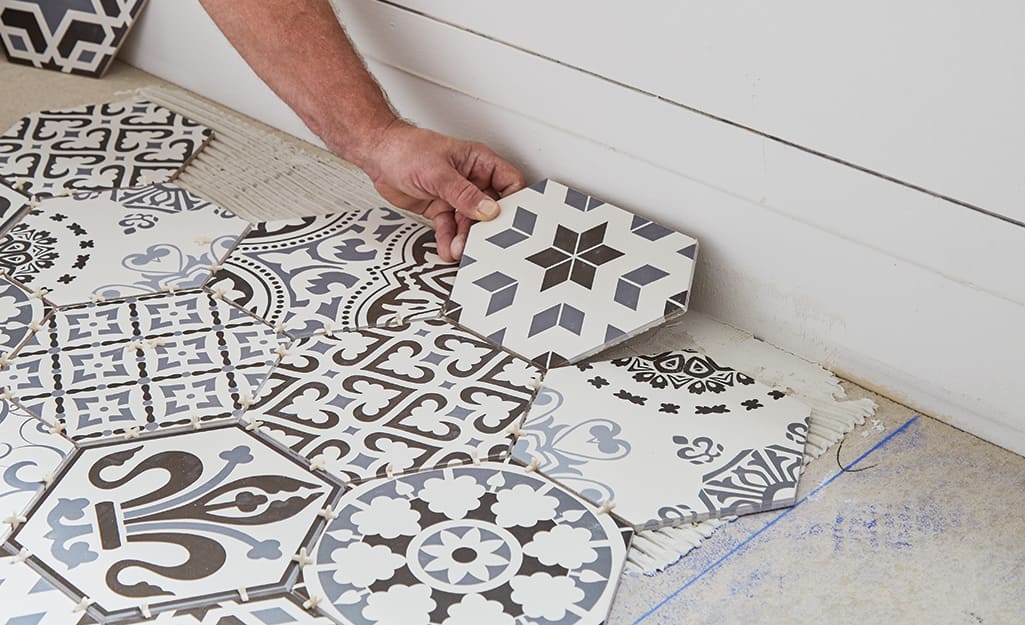 Person placing tile near a wall. Person placing tile near a wall.