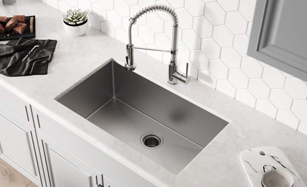 An undermount sink set in a marble countertop.