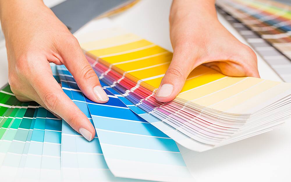 A person looking through a paint chip fan deck. A person looking through a paint chip fan deck.