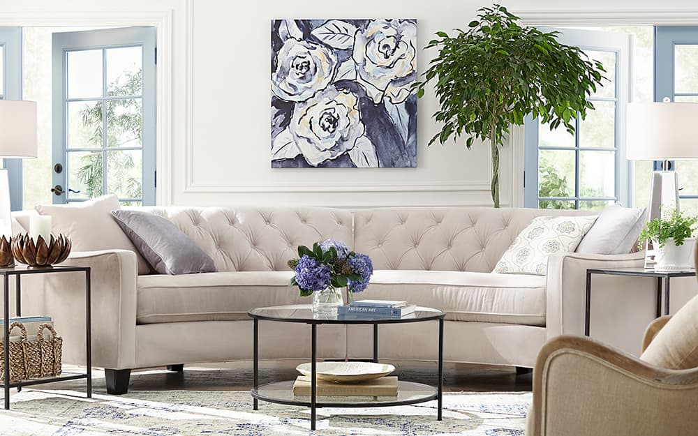 A living room with white sectional sofa and large framed art. A living room with white sectional sofa and large framed art.