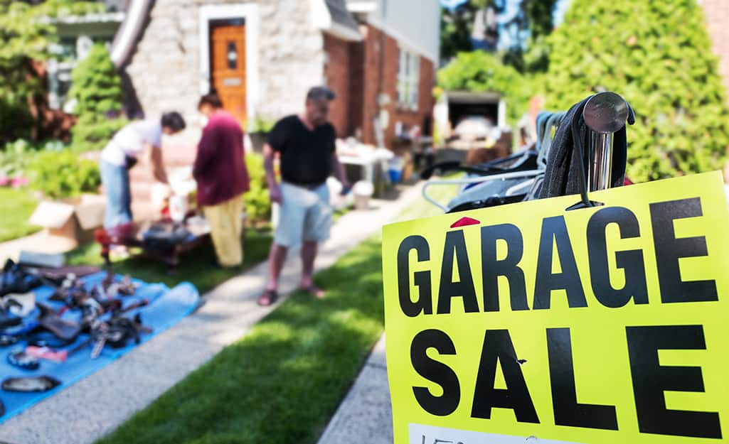 People host a garage sale in their front yard. People host a garage sale in their front yard.