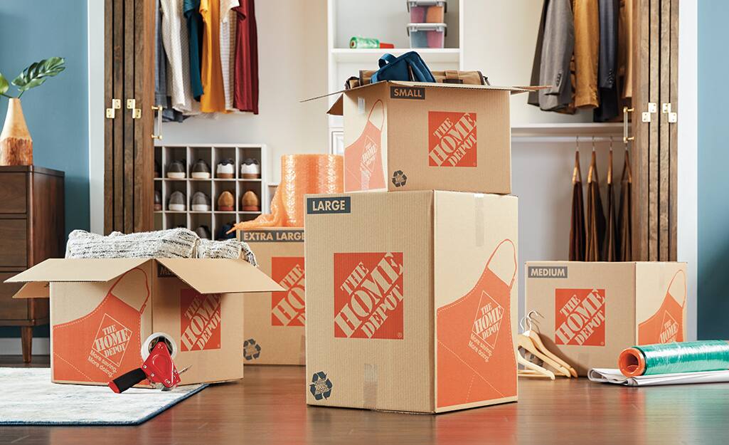 Several Home Depot moving boxes stacked in a closet. Several Home Depot moving boxes stacked in a closet.