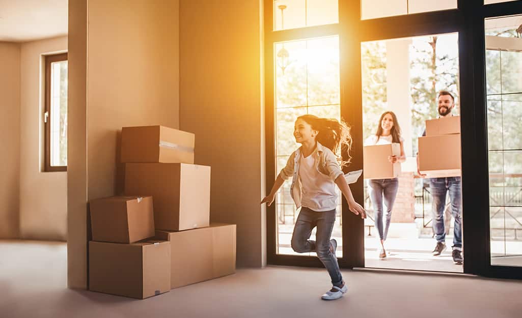 Girl running into new house full of moving boxes. Girl running into new house full of moving boxes.