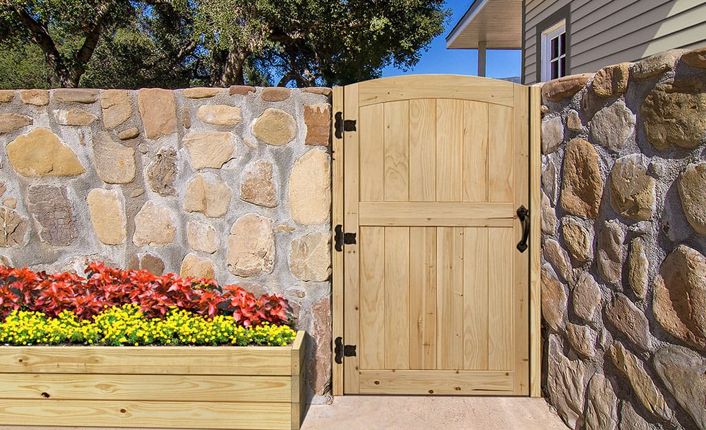A stone fence with a wooden gate. A stone fence with a wooden gate.