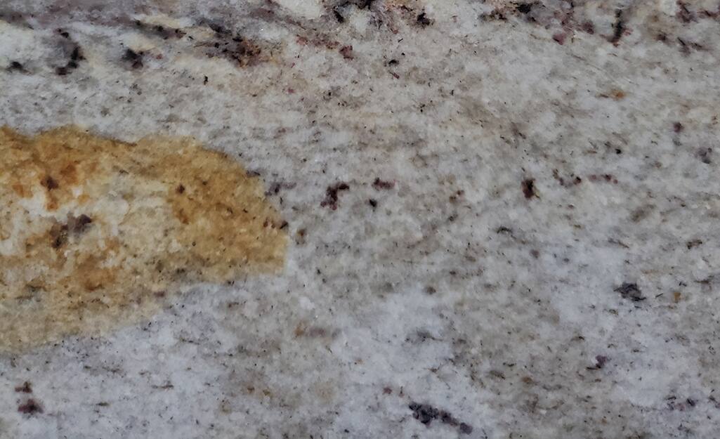 Light granite countertop with a dark sauce stain. Light granite countertop with a dark sauce stain.