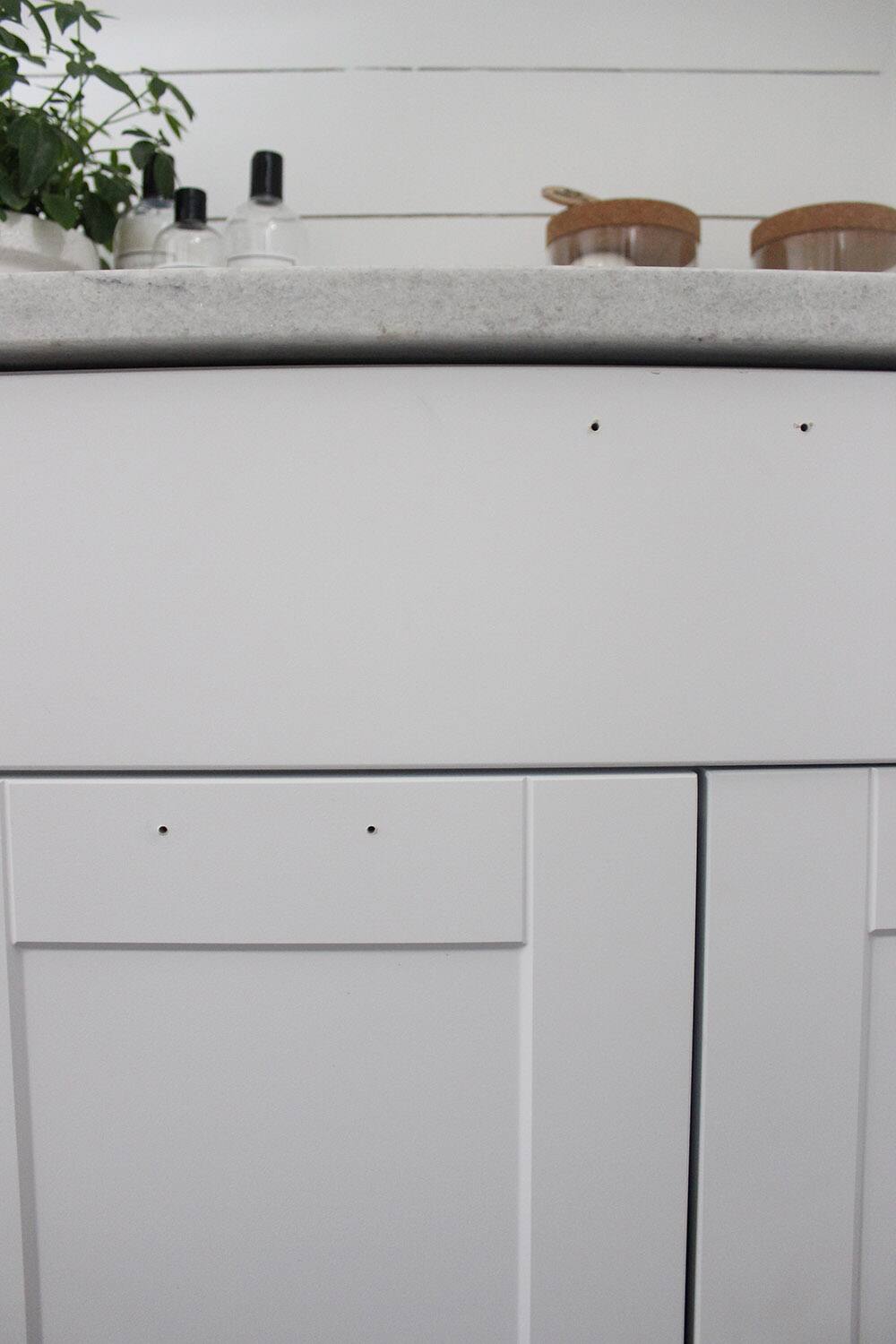 A granite countertop with white cabinets.