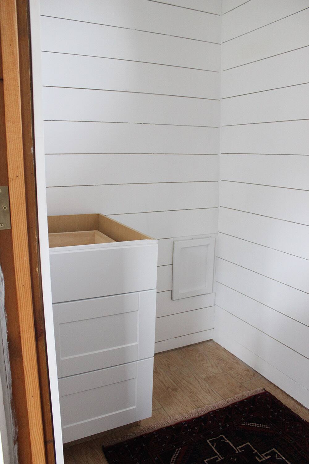 A room with white plank walls.