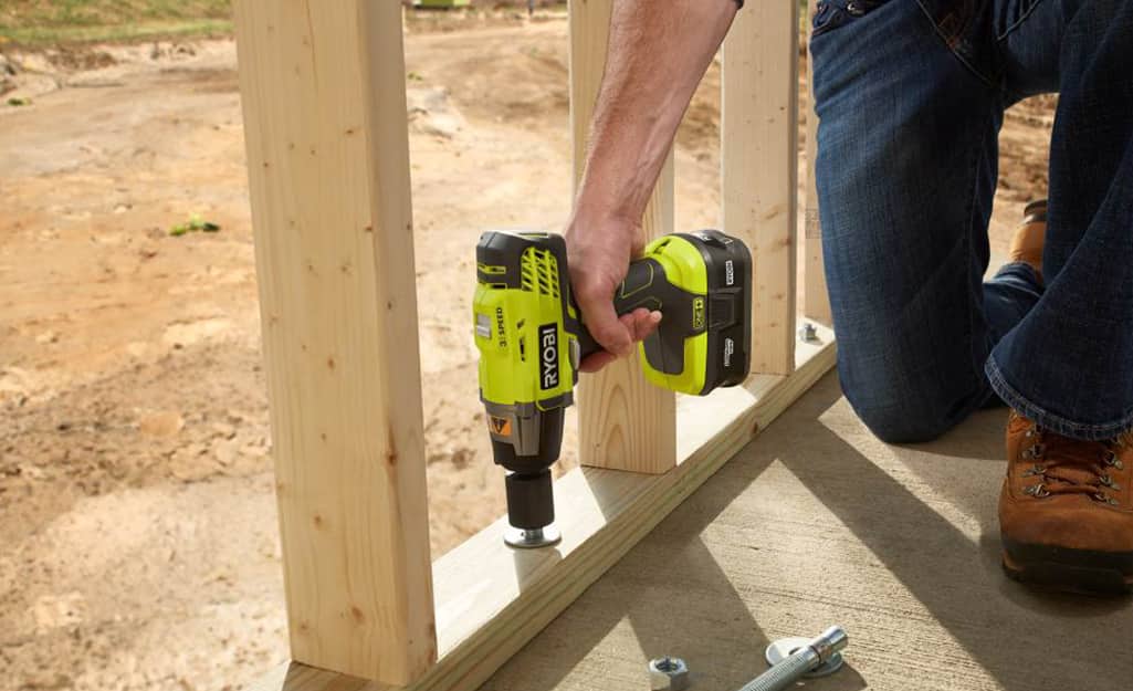A worker uses a drill powered by a lithium-ion battery. A worker uses a drill powered by a lithium-ion battery.