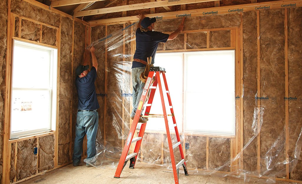 Two people installing vapor barriers.