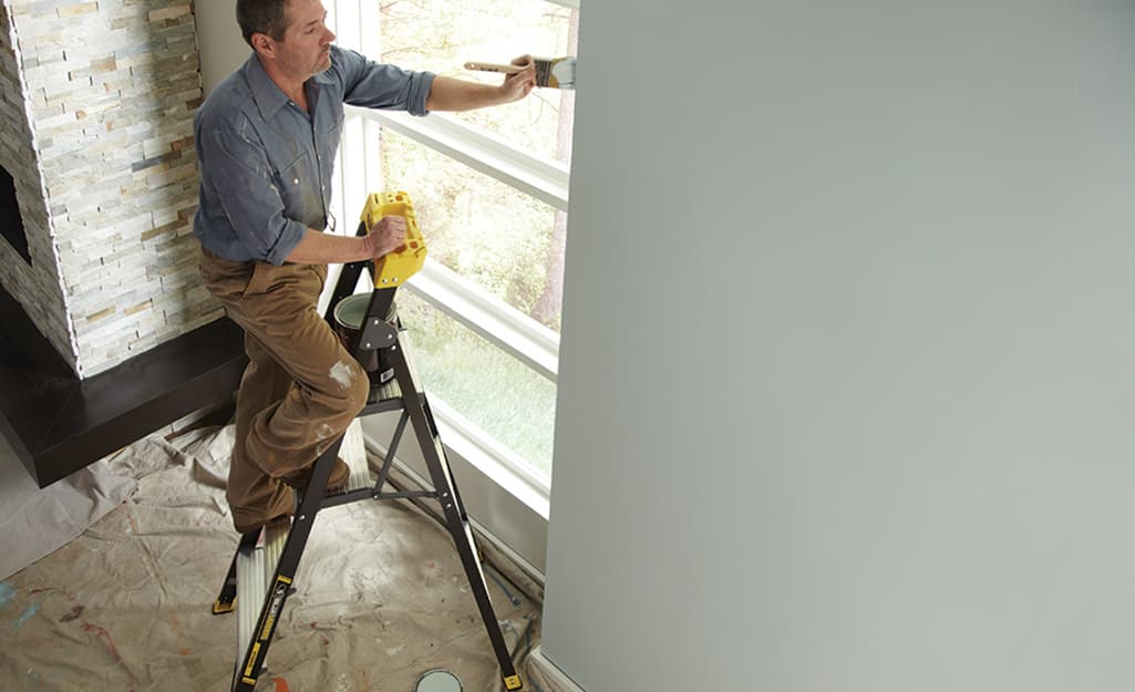 Man standing on a ladder to paint. Man standing on a ladder to paint.