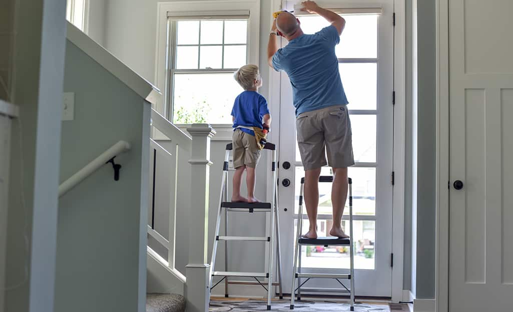 A father and a child each on a step ladder. A father and a child each on a step ladder.