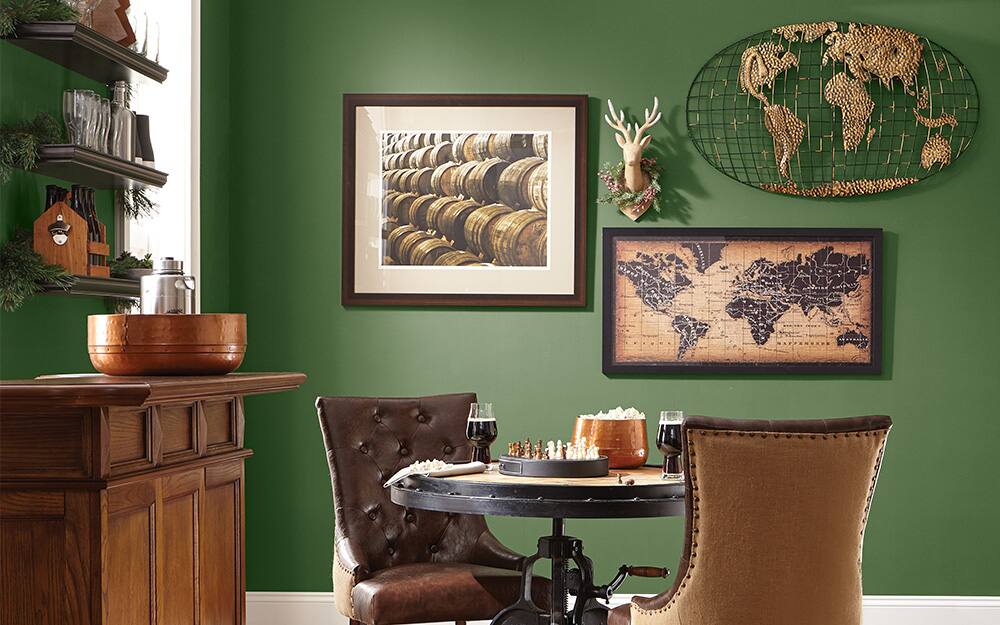 Framed maps used behind a table and two chairs as wall art.