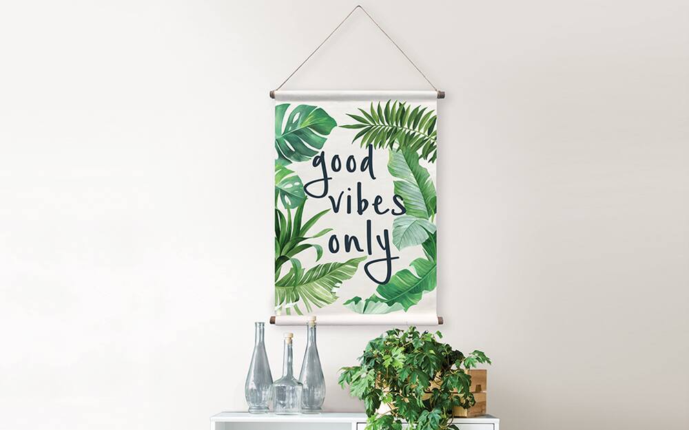 A canvas reading "good vibes only" hanging from a rope and used as wall art.