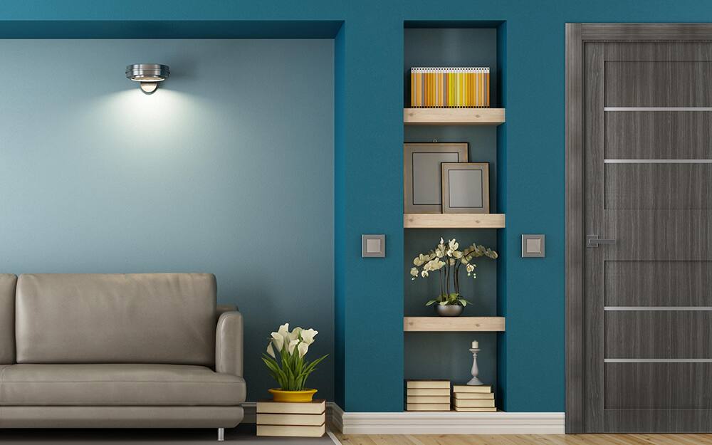 A niche in a living room wall holding wall art.