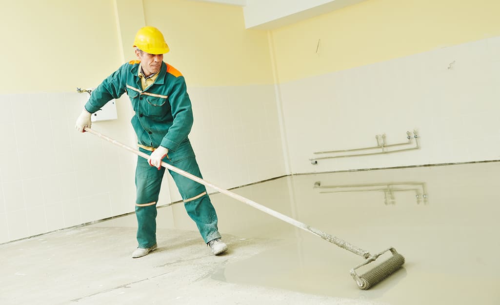 Person applying sealer to a basement. Person applying sealer to a basement.