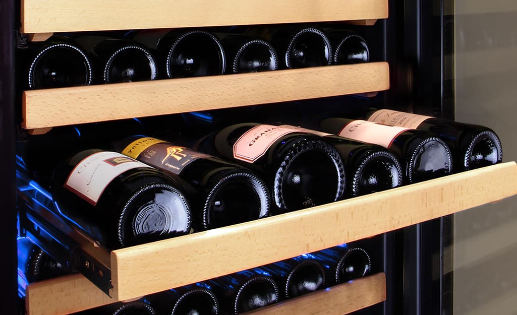 Six bottles of wine laying on a shelf inside a wine cooler. Six bottles of wine laying on a shelf inside a wine cooler.