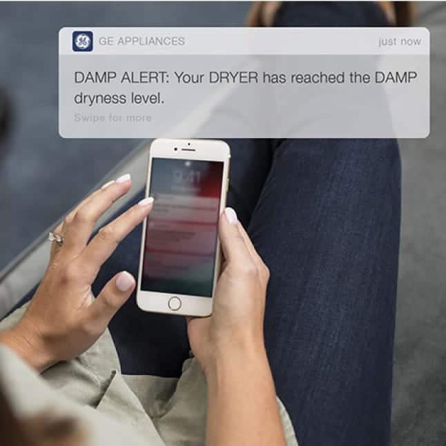 A notification pops up on a phone, letting the user know their clothes are still damp